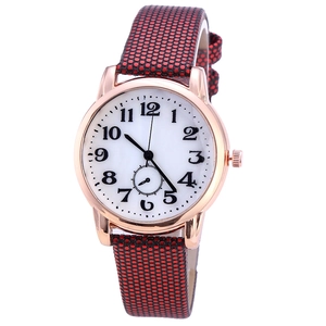 Close-up of minimalist rose gold watch with white dial and red black polka dot leather strap