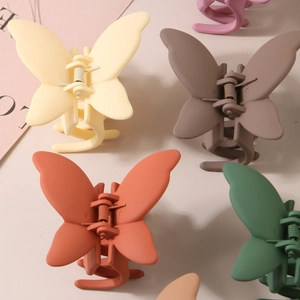 Detailed close-up of matte butterfly hair claws in various earthy and pastel colors