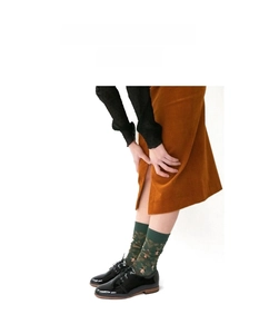 Detail of dark green cotton socks with artistic patterns paired with vintage loafers