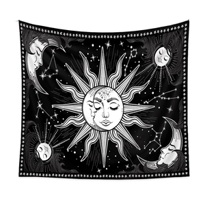 Detail of bohemian sun and moon tapestry with white celestial patterns on black fabric