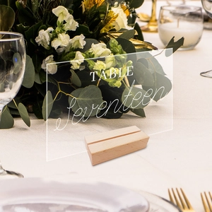 Detail of clear acrylic wedding table number seventeen with elegant wooden stand