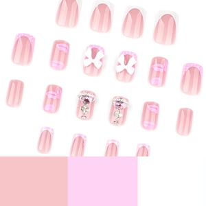 Faux ongles roses avec breloques cœur, nœuds et imprimés lèvres au style français