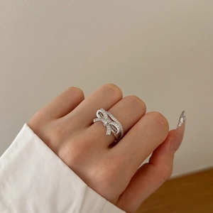 Macro detail of silver bow ring with shimmering pave zircons on woman finger