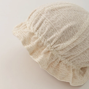 Detailed close-up of intricate lace texture and ruffled brim on a baby princess hat