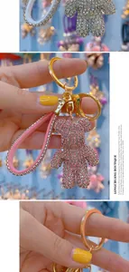 Detail shot of a pink rhinestone bear keychain with matching crystal wrist strap and gold ring