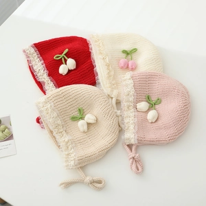 Lace-trimmed knitted baby hats in red, cream, pink and khaki with floral details