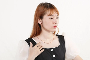 Gros plan d'un collier avec pendentif cœur en or rose porté par un mannequin féminin