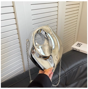 Detail of silver acrylic mirror handbag with irregular fluid sculpture shape and chain
