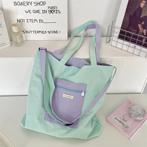 Close-up of mint green and lavender tote bag with adjustable strap and front pocket