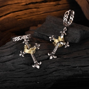 Vintage Thai silver cross earrings with gold crown accents on textured charcoal surface