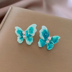 Vue macro de boucles d'oreilles papillon turquoise avec émail et strass étincelants