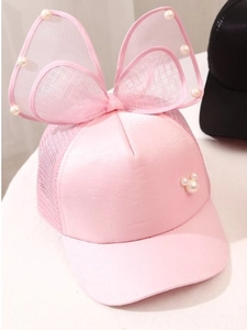 Detailed view of pink mesh kids cap with large lace bow and elegant pearl decorations