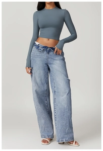 Detail of grey-blue tight long-sleeve yoga top featuring thumb holes and cropped fit