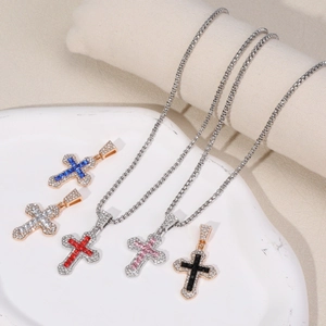 Close-up of colorful crystal cross necklaces in silver and gold metal finishes