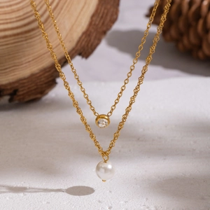 Double-layered gold stainless steel necklace featuring zircon pendant and white pearl