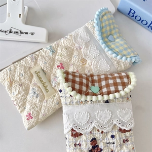 Macro detail of quilted padded eyeglass pouch with lace trim and bear print