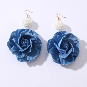 Denim camellia flower earrings with pearls and gold hooks on a plain white background
