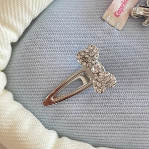 Close-up of heart bow hair clip with white rhinestones and a silver metal finish