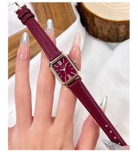 Vue détaillée d'une montre quartz rectangulaire dorée avec bracelet en cuir bordeaux