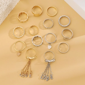 Detailed close-up of mixed metal rings set with pearls and LOVE letter charms