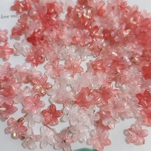 Close-up of mini gradient pink and clear resin flower beads with gold foil flakes