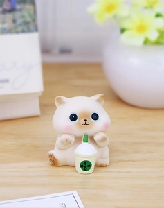 Close-up of a cute resin cat figurine holding a milk tea cup for desk decoration