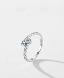 Macro detail of S925 sterling silver ring featuring double heart-shaped stones and pavé diamonds
