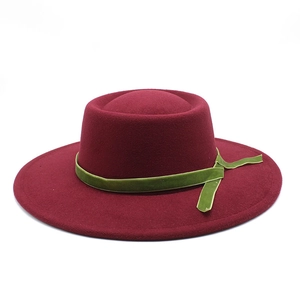 Close-up of burgundy wool felt hat featuring olive green velvet decorative ribbon