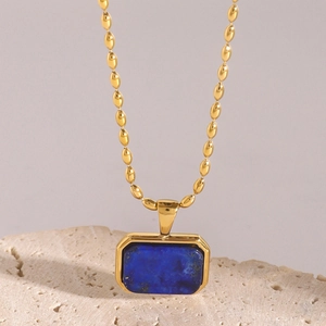 Gold stainless steel chain necklace with square blue tiger eye stone pendant on rock