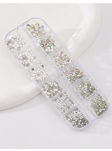 Detail of 12-grid organizer box filled with multi-sized silver and iridescent nail rhinestones