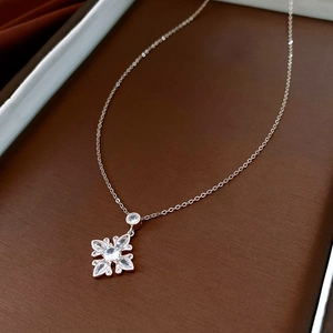 Macro shot of silver zircon flower pendant necklace on a premium leather jewelry box