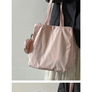Pink nylon tote bag with matching coin purse shown on a model's shoulder for casual wear