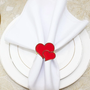 Elegant red double heart napkin ring with gold edges on white fabric for hotel decor