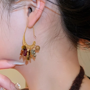 Close-up of vintage 18k gold plated tassel earrings with colorful beads on a model