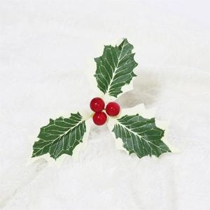 Detail of faux holly leaves and red berries on a soft white plush decorative background