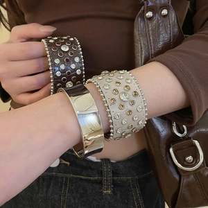 Vue détaillée d'un bracelet manchette en cuir clouté de strass sur un poignet