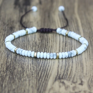 Detailed close-up of woven stone bead bracelet with golden spacers and adjustable cord