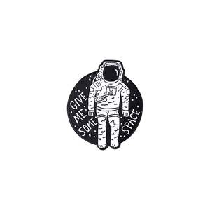 Pin's émaillé astronaute avec texte 'GIVE ME SOME SPACE' sur badge rond en métal noir et blanc