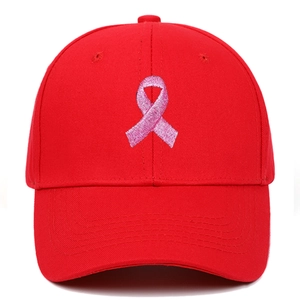 Detailed close-up of pink ribbon embroidery on a red hard-top baseball cap for sports