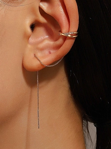 Macro shot of gold tassel ear cuff with chain and rhinestones on a female ear