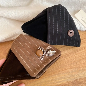 Nahaufnahme von Vintage-Dreieckshaarspangen mit Stofftexturen und Knopfverzierungen