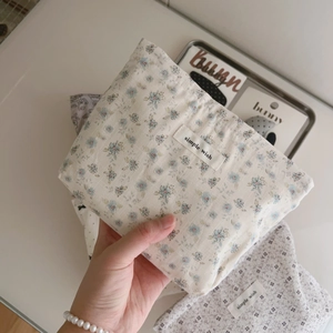 Close-up of a small floral cotton makeup bag with a simple wish fabric label