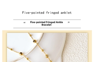 Detail of gold star and tassel anklet with black and white cubic zirconia stones