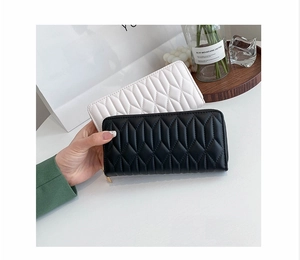 Detail of quilted diamond pattern and golden zipper on black and white long PU purses