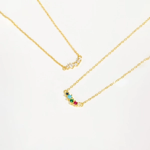 Gold arc necklace with rainbow gemstones and clear zircon pendant on fine chain