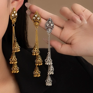 Detail of vintage bohemian Jhumka earrings with triple bell tassels and sparkling rhinestones