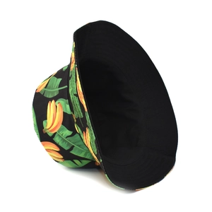 Detailed view of reversible banana print bucket hat with tropical leaves on black canvas