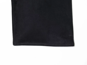 Détail de la texture suédée noire et coutures soignées sur le poignet de chemise