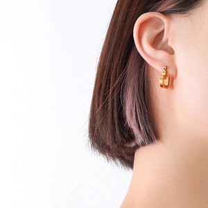 French style 18k gold plated hollow heart earrings on a female model with u-shape design