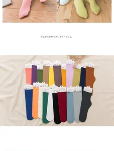 Detailed set of colorful nylon velvet socks with ribbed cuffs and branded tags on wood